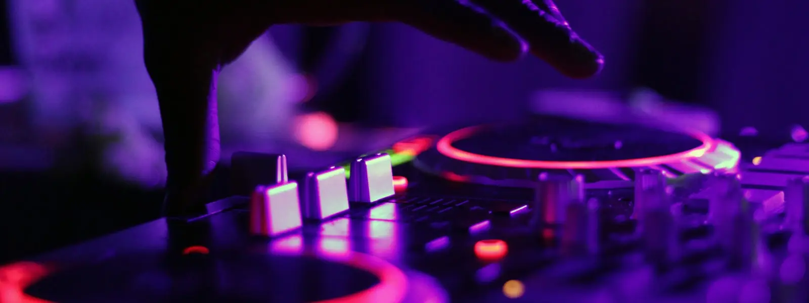 A DJ silhouetted against red booth light