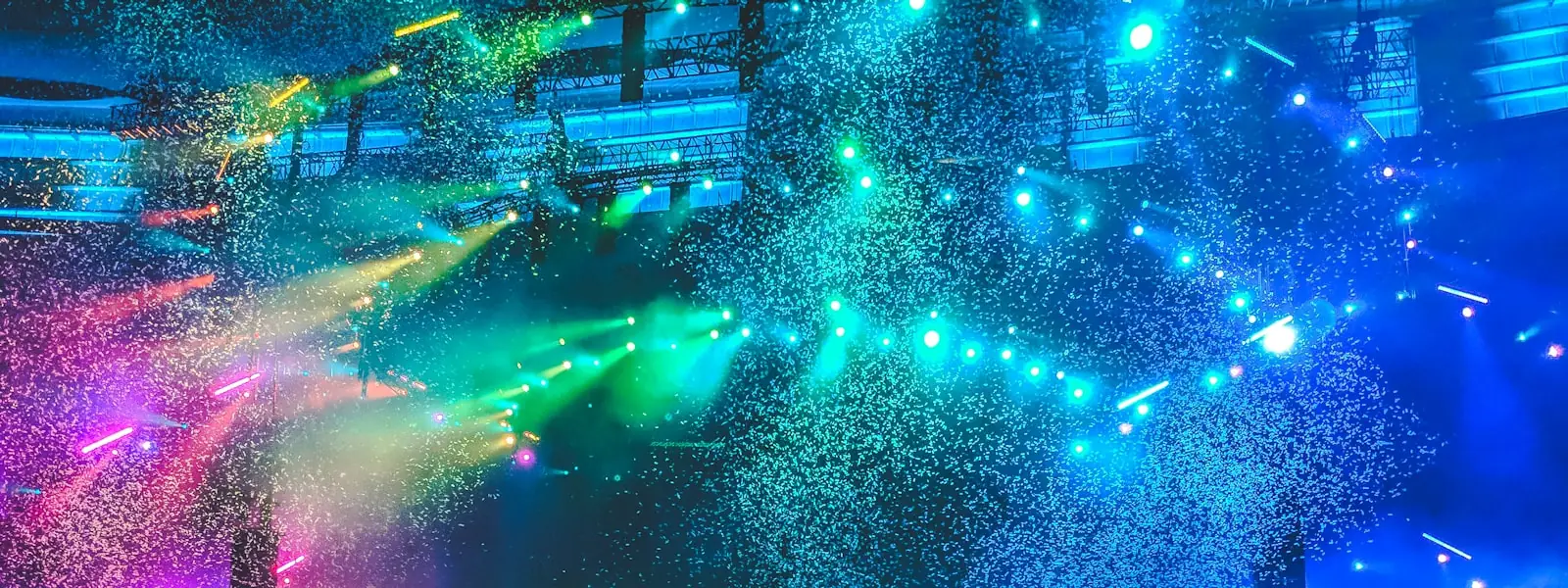 A crowd facing a lit stage